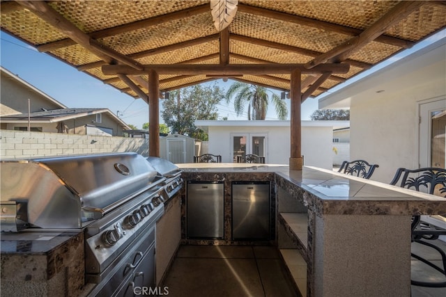 view of patio / terrace featuring an outdoor kitchen, area for grilling, fence, and outdoor wet bar