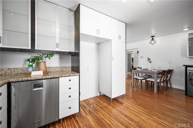 kitchen featuring white cabinets, dark wood-style floors, washer / clothes dryer, glass insert cabinets, and dark stone countertops