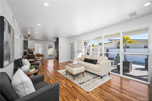 living area featuring recessed lighting, visible vents, baseboards, and wood finished floors