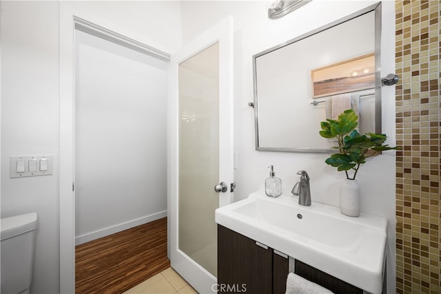 bathroom featuring baseboards, toilet, and wood finished floors