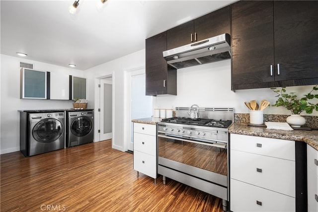 kitchen with visible vents, washing machine and dryer, dark brown cabinetry, under cabinet range hood, and stainless steel gas range oven