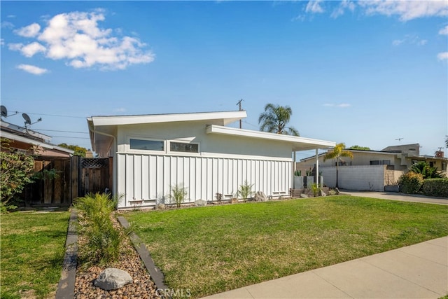 view of front facade with driveway, a front yard, fence, and stucco siding