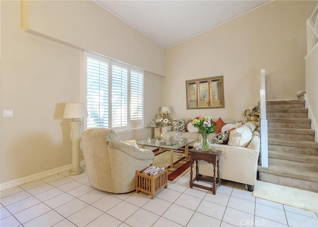 living room with light tile patterned floors, baseboards, and stairway