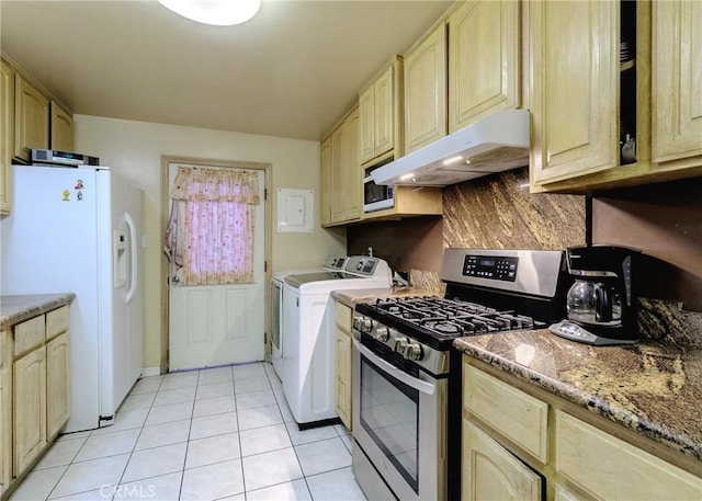 kitchen with light tile patterned floors, light brown cabinets, under cabinet range hood, white appliances, and independent washer and dryer