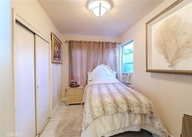 bedroom featuring light tile patterned floors, a closet, baseboards, and cooling unit