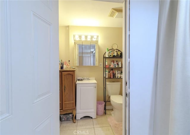 half bathroom with vanity, tile patterned flooring, and toilet