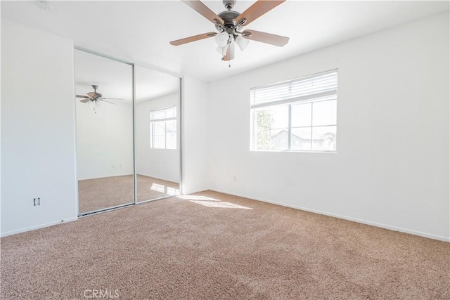 unfurnished bedroom featuring carpet flooring, ceiling fan, and a closet