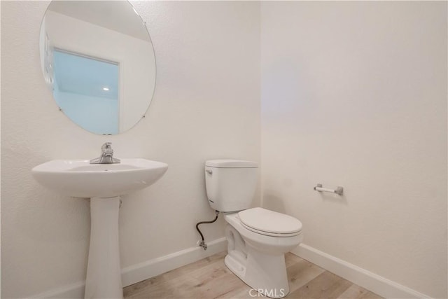 bathroom featuring wood-type flooring and toilet