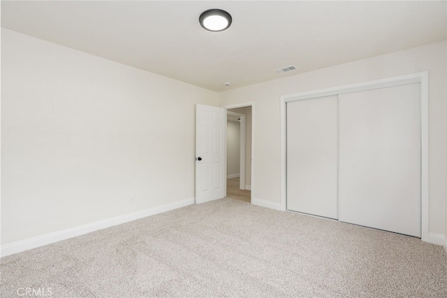 unfurnished bedroom featuring carpet floors and a closet