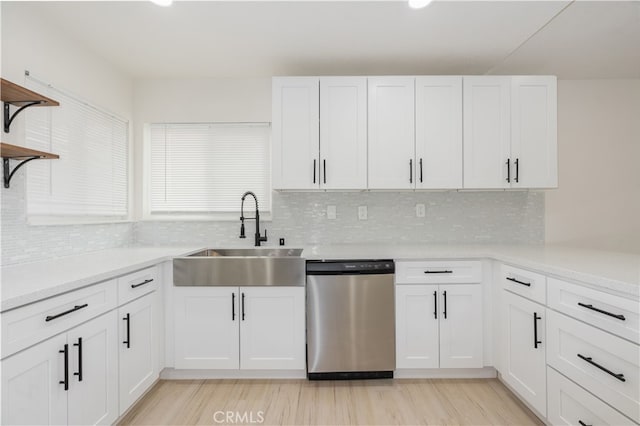 kitchen featuring white cabinetry, sink, light hardwood / wood-style floors, and dishwasher