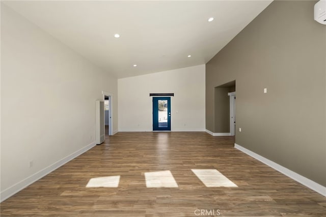 60785 La Brisa Dr, Joshua Tree, CA 92252 - unfurnished living room featuring high vaulted ceiling, recessed lighting, baseboards, wood finished floors, and a wall mounted AC