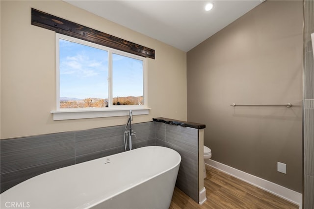 bathroom featuring hardwood / wood-style flooring, toilet, and a bathing tub