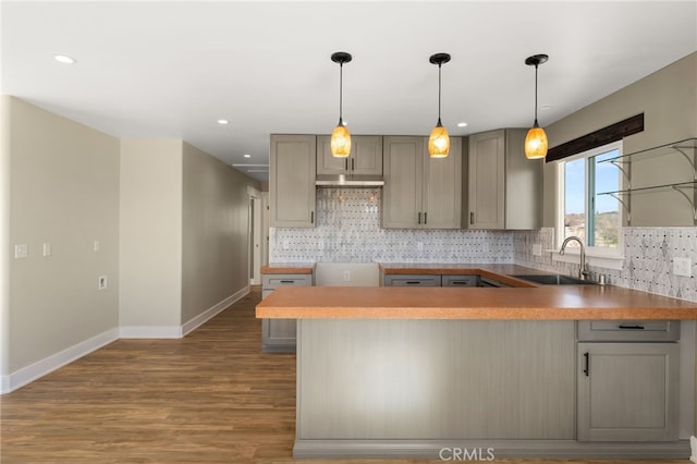 kitchen featuring tasteful backsplash, gray cabinets, sink, and hardwood / wood-style floors