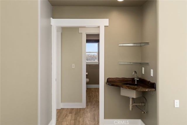 bathroom featuring wood-type flooring, sink, and toilet