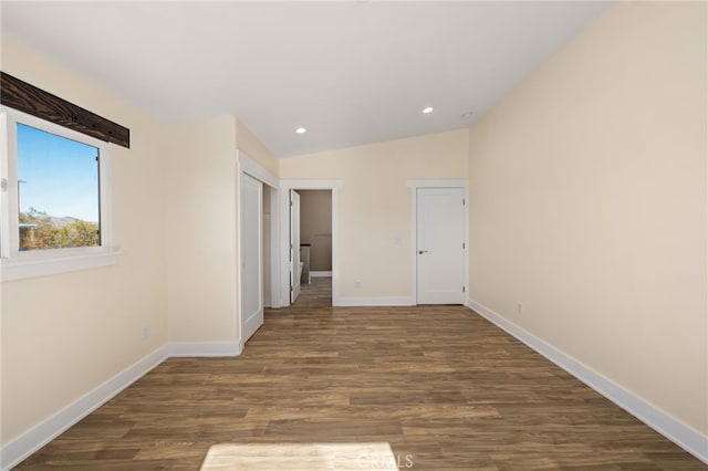 interior space featuring dark wood-type flooring and vaulted ceiling