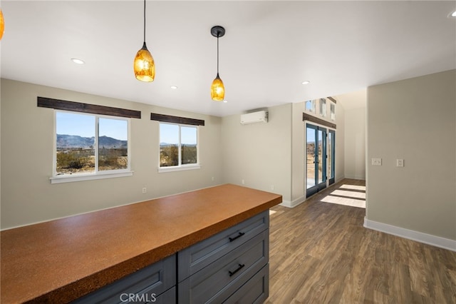 kitchen with dark wood-type flooring, hanging light fixtures, a wall mounted air conditioner, a mountain view, and french doors