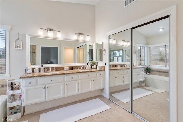 bathroom with vanity and a tub to relax in