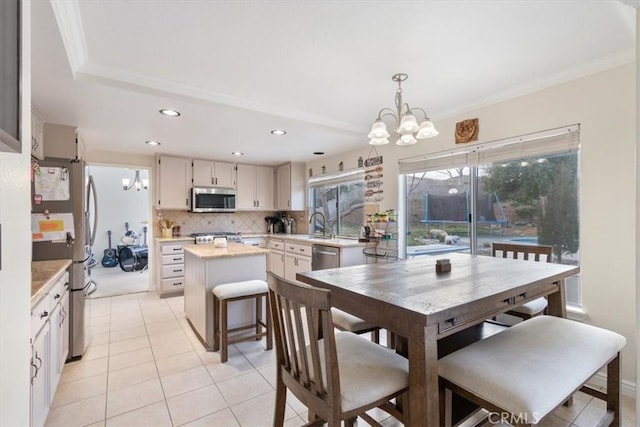 dining space featuring an inviting chandelier, crown molding, and light tile patterned flooring