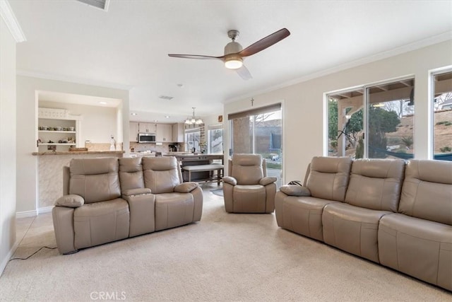 carpeted living room featuring crown molding and ceiling fan with notable chandelier