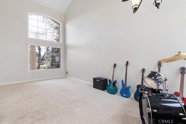 miscellaneous room with high vaulted ceiling and carpet