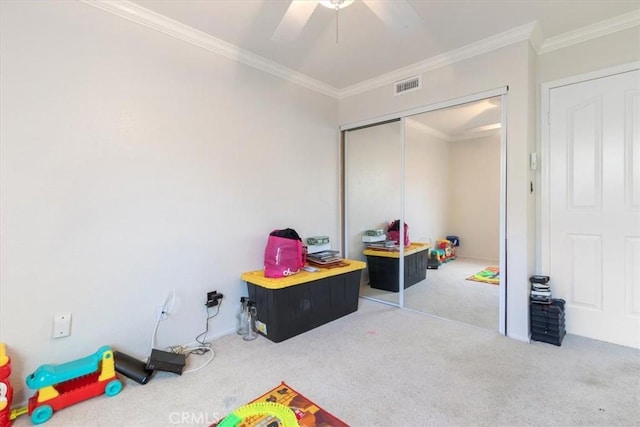 recreation room with ornamental molding, carpet, and ceiling fan