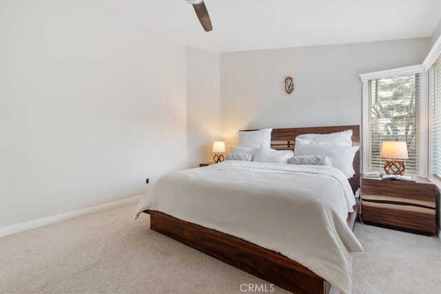 bedroom featuring ceiling fan, light carpet, and baseboards