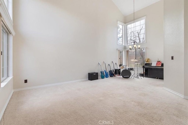 interior space featuring carpet floors, high vaulted ceiling, and a chandelier