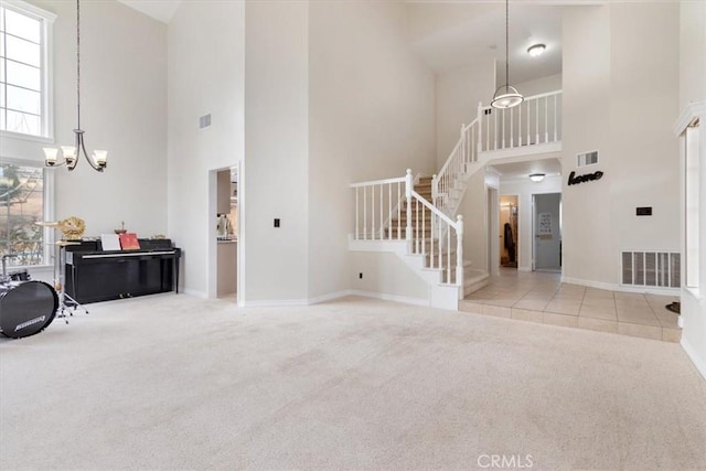 carpeted foyer entrance with an inviting chandelier