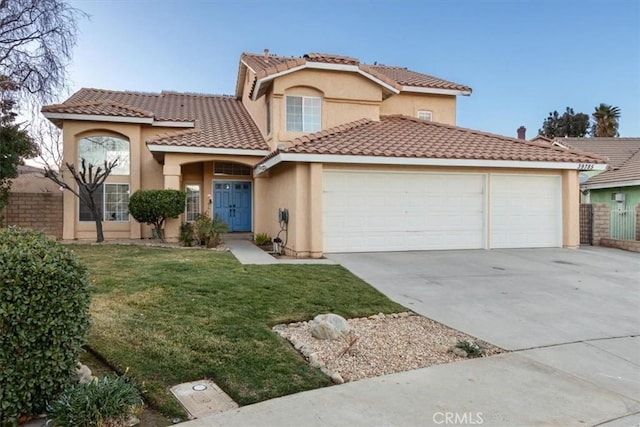 mediterranean / spanish-style house featuring a garage and a front lawn