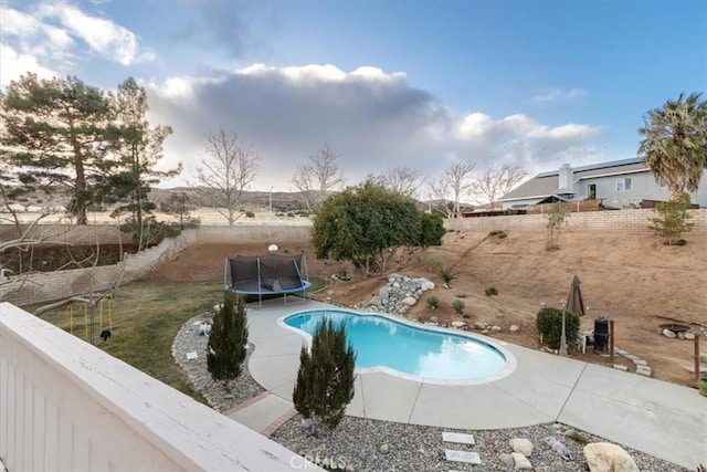 view of swimming pool with a trampoline