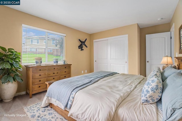 bedroom with light carpet and a closet