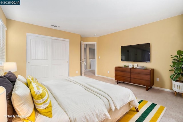 bedroom featuring light carpet and a closet