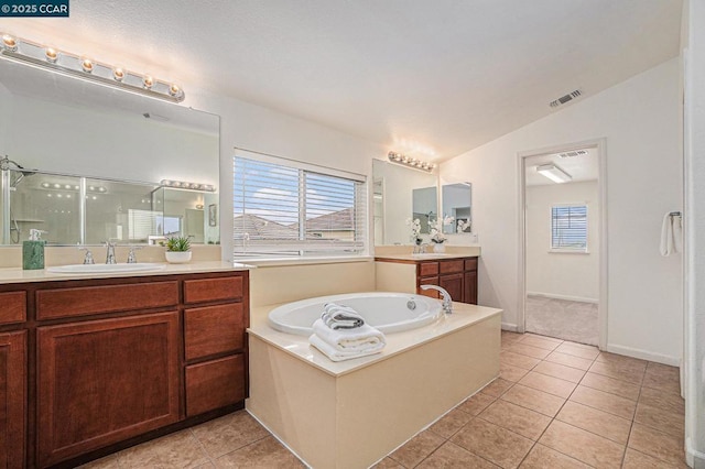 bathroom with vanity, vaulted ceiling, tile patterned floors, and plus walk in shower