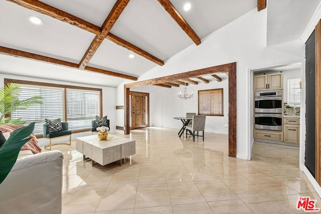 living room with beam ceiling, high vaulted ceiling, and a chandelier