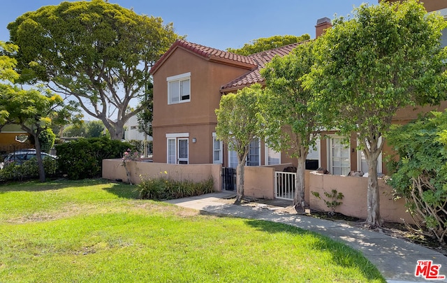 rear view of property featuring a lawn