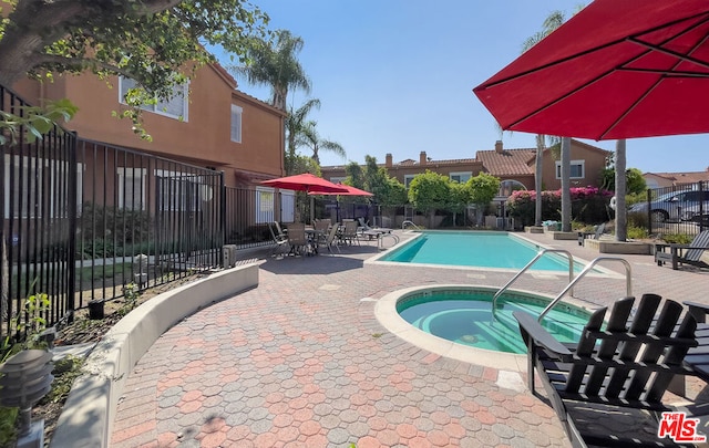 view of swimming pool with a hot tub and a patio