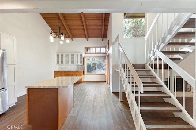 staircase featuring hardwood / wood-style flooring, wooden ceiling, high vaulted ceiling, beamed ceiling, and a chandelier