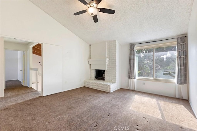 unfurnished living room with vaulted ceiling, carpet flooring, a textured ceiling, ceiling fan, and a fireplace