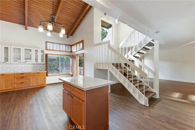 kitchen featuring dark hardwood / wood-style flooring, a kitchen island, beam ceiling, and wood ceiling