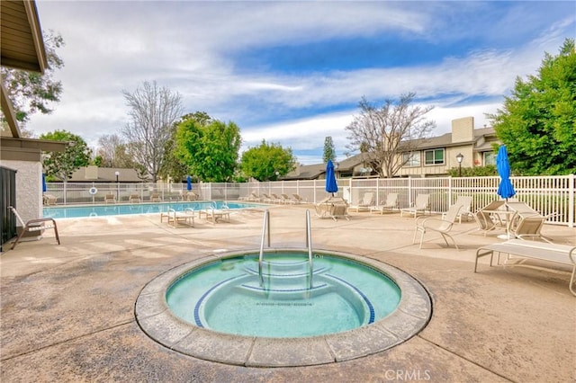 view of swimming pool with a patio and a hot tub