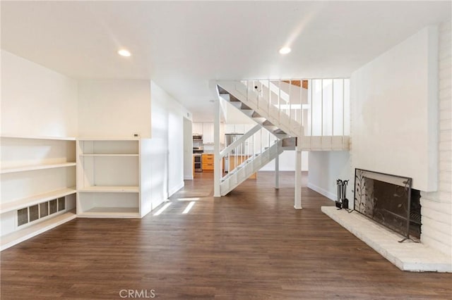 unfurnished living room featuring dark hardwood / wood-style floors and a brick fireplace