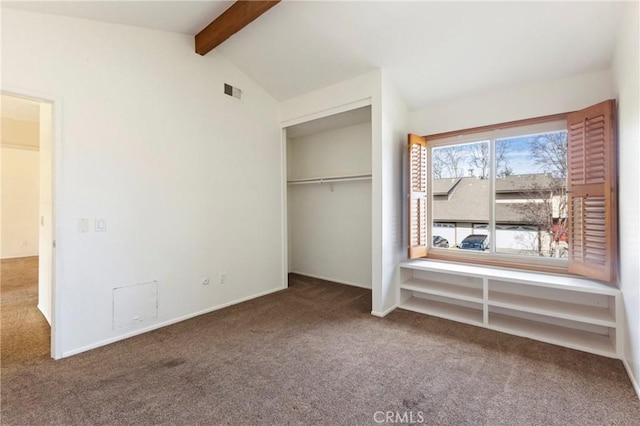 unfurnished bedroom with carpet, a closet, and vaulted ceiling with beams