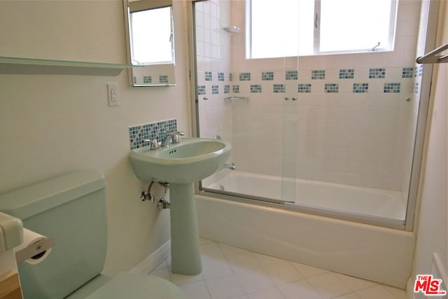 bathroom with decorative backsplash, bath / shower combo with glass door, and toilet