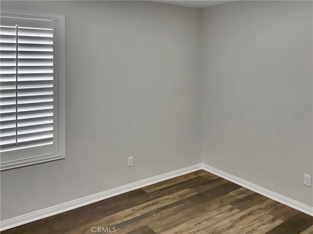 empty room featuring dark wood-type flooring and a wealth of natural light