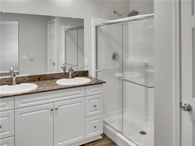 bathroom with vanity, hardwood / wood-style floors, and a shower with shower door