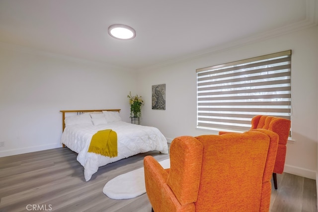 bedroom with hardwood / wood-style flooring and crown molding