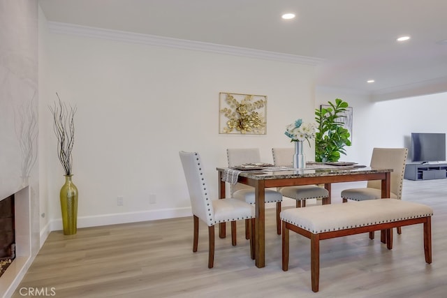 dining room featuring ornamental molding and light hardwood / wood-style floors