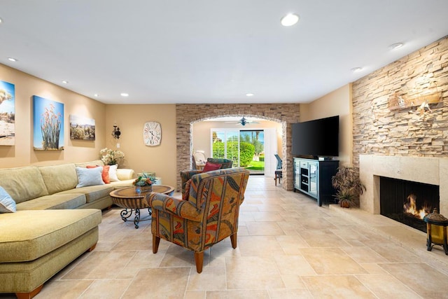 living room featuring a fireplace and ceiling fan