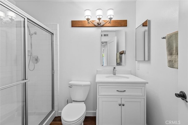 bathroom with vanity, a shower with shower door, and toilet