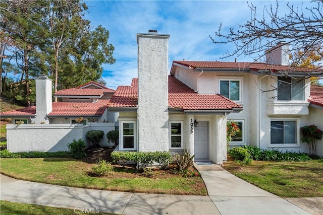 mediterranean / spanish house with a front lawn